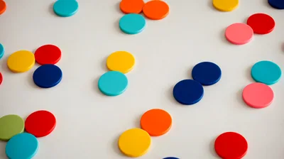 Colorful Plastic Discs Scattered on a White Surface