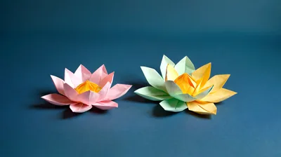 Two Handmade Origami Lotus Flowers On Blue Background