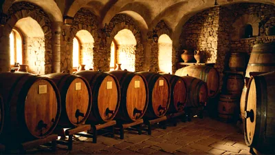 Wine Barrels Stored In A Traditional Stone Cellar
