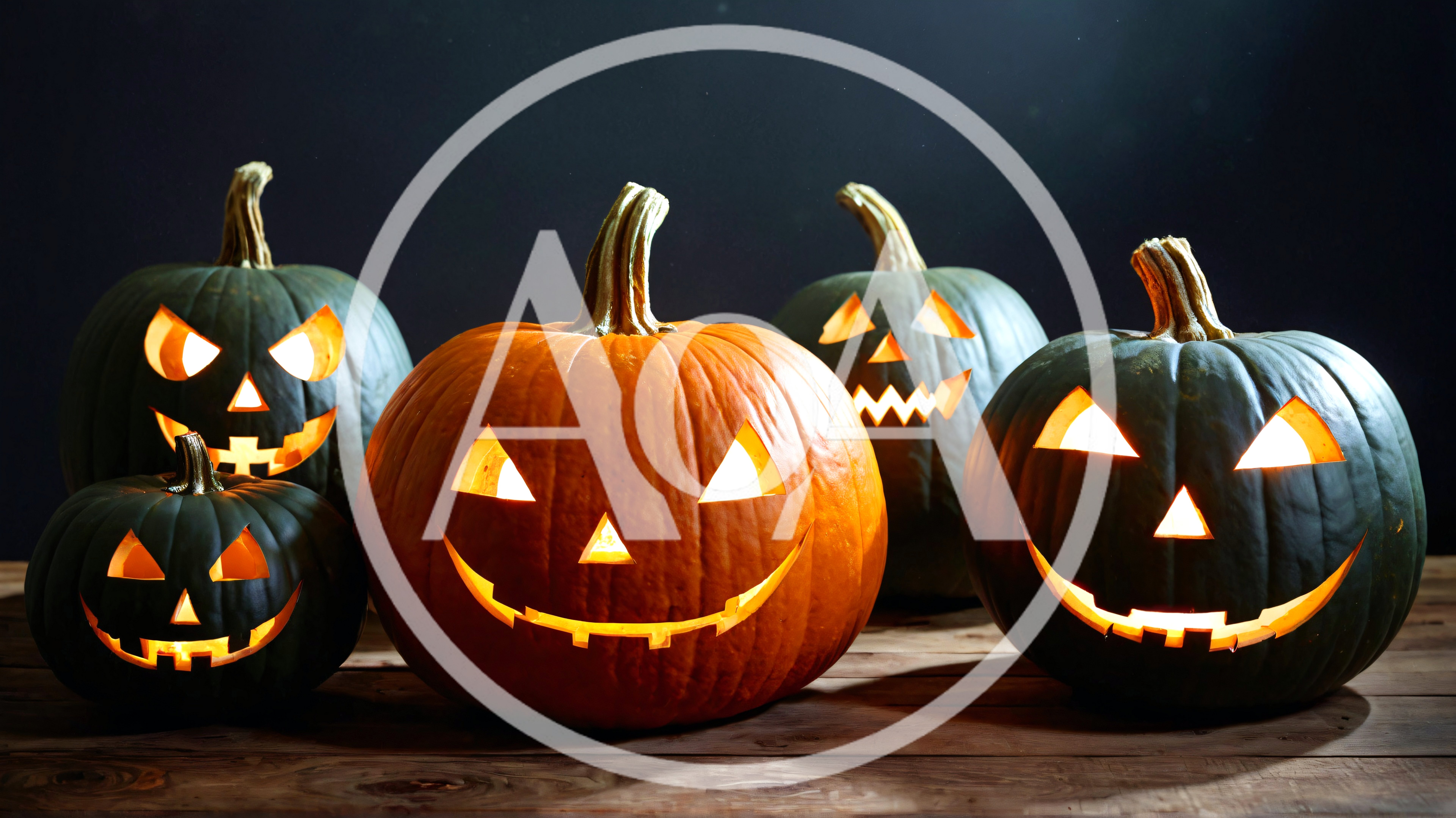 Five Glowing Jack O Lanterns On Wooden Table
