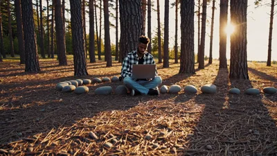 Young Man Working on Laptop in Pine Forest