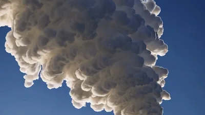 Thick White Smoke Billowing Into Clear Blue Sky