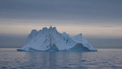 Large Iceberg Floating In Calm Arctic Ocean Waters