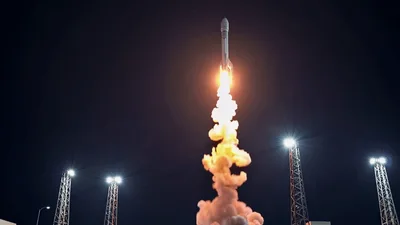 Rocket Launching Into Night Sky From Launchpad