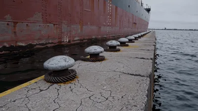 Large Cargo Ship Docked Along Concrete Pier