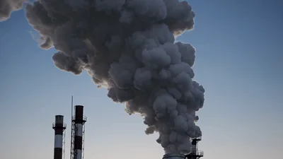 Industrial Chimneys Emitting Thick Smoke Into Clear Sky