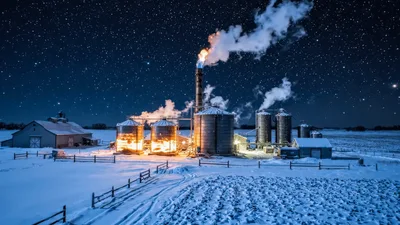 Industrial Grain Silos Emitting Smoke Under Starry Night Sky