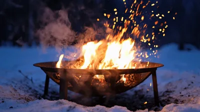 Burning Fire Pit In Snowy Winter Forest Setting