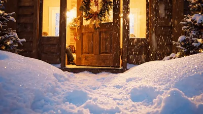 Family Relaxing By Christmas Tree Inside Cozy Cabin