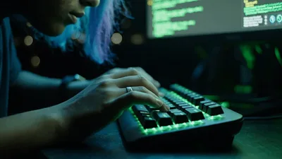 Young Programmer Typing Code On Illuminated Mechanical Keyboard