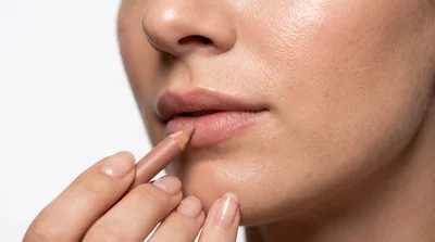 Woman Applying Nude Lip Liner To Lips