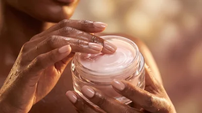 Woman Applying Pink Moisturizing Cream From Glass Jar