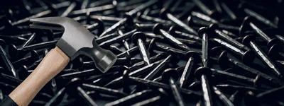 Hammer Resting On A Pile Of Common Metal Nails