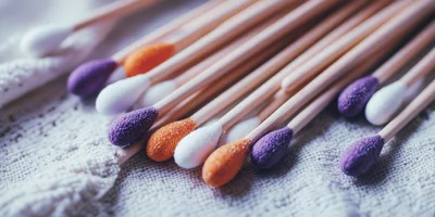 Colorful Cotton Swabs Arranged On Textured Fabric