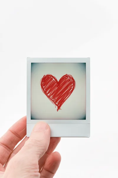 Hand Holding A Polaroid Photo With A Red Heart