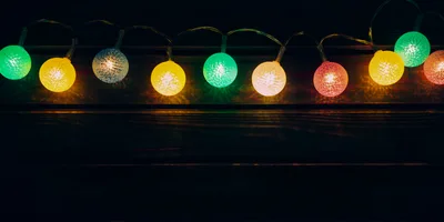 Colorful Decorative String Lights Against Dark Wooden Background