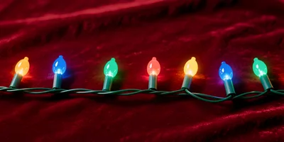 Colorful Christmas String Lights On Red Velvet Fabric