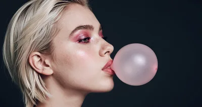 Young Woman Blowing A Pink Bubblegum Bubble