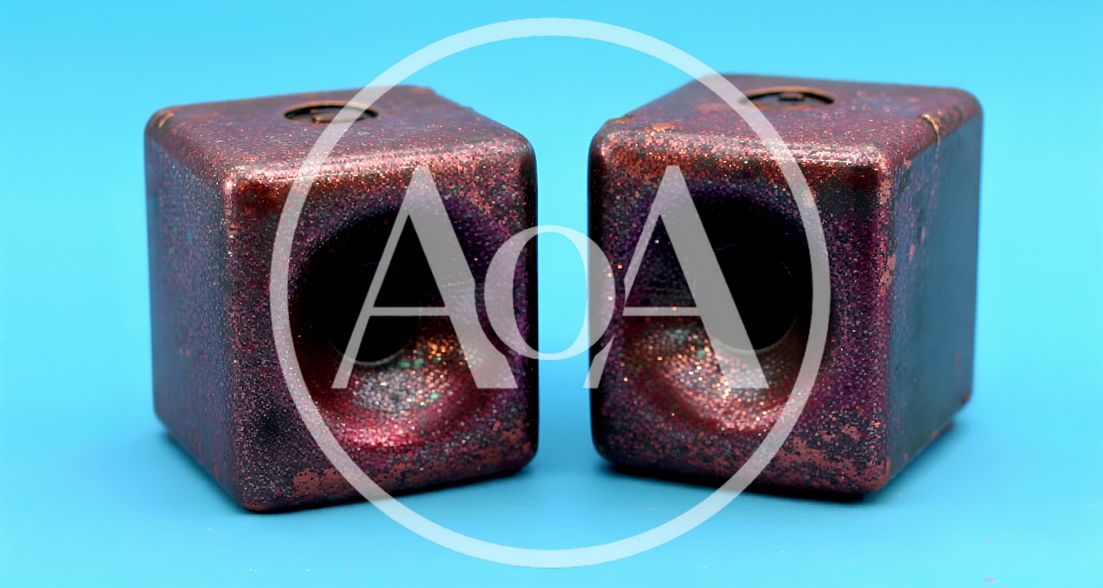 Two Glittery Red Cube Speakers On Blue Background