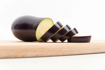 Sliced Fresh Eggplant On A Wooden Cutting Board