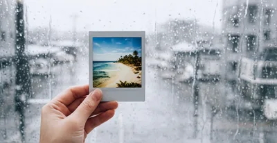 Hand Holding Polaroid Photo Of Tropical Beach