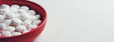White Medical Pills In A Red Bowl