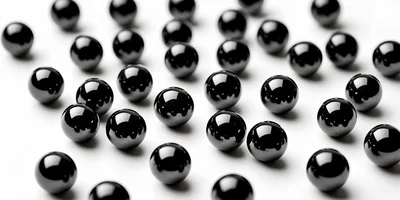 Shiny Black Spheres Scattered On A White Surface