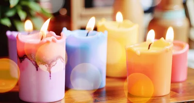 Colorful Lit Pillar Candles On A Wooden Table