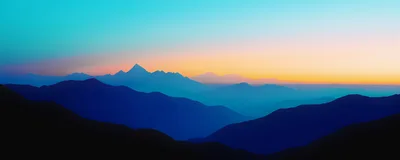 Panoramic View Of Layered Mountain Silhouettes At Sunset