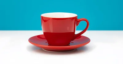 Red Ceramic Coffee Cup And Saucer On White Surface