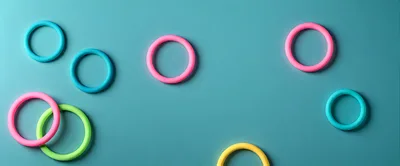 Colorful Plastic Rings Arranged On A Teal Background