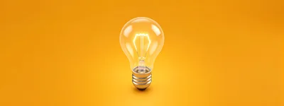Glowing Light Bulb On Solid Yellow Background