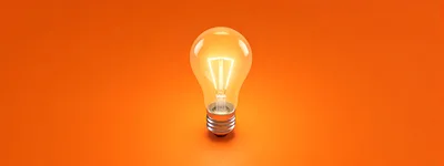 Glowing Light Bulb On Orange Background