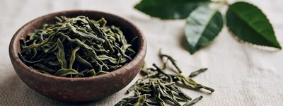 Dried Green Tea Leaves in a Rustic Bowl