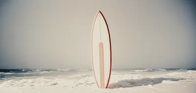 Vintage Surfboard Standing Upright On A Sandy Beach