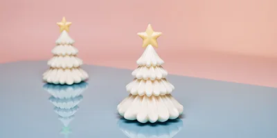 Two Decorative Ceramic Christmas Trees on Reflective Surface