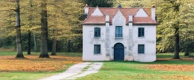 Historic White Country House Surrounded By Autumn Trees