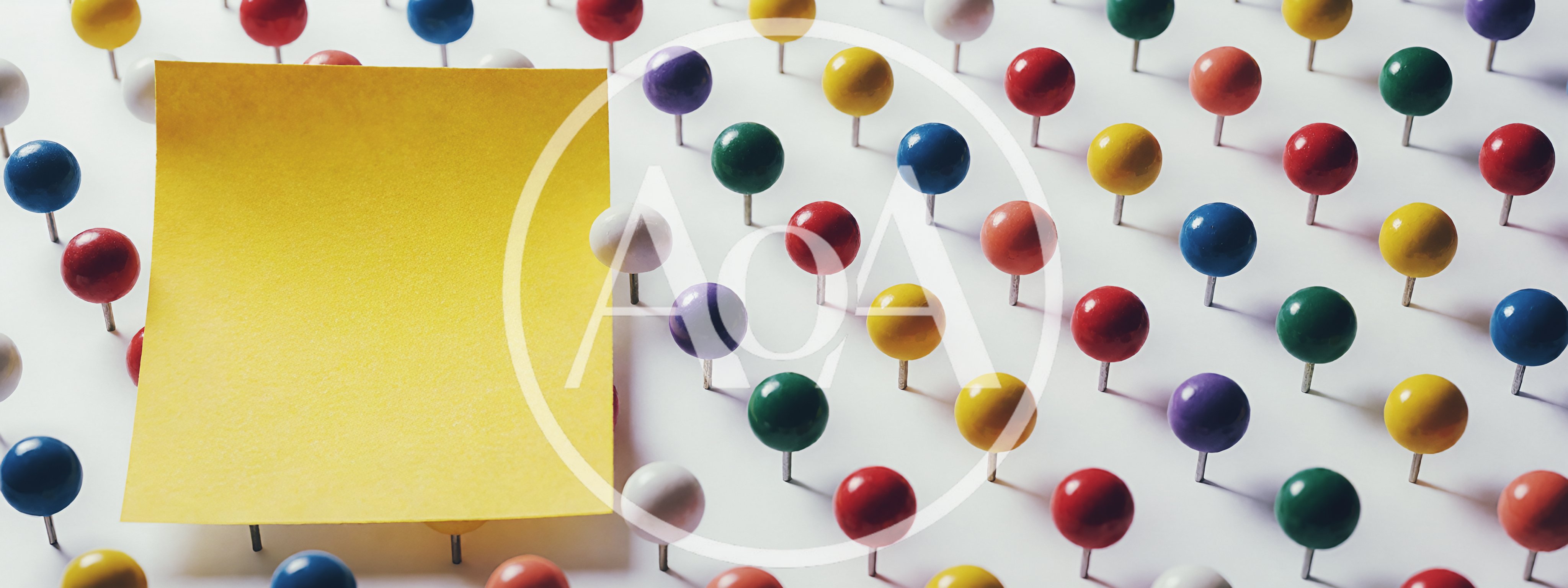 Yellow Sticky Note Surrounded By Colorful Push Pins