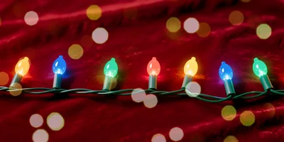 Colorful Christmas String Lights On Red Velvet Fabric