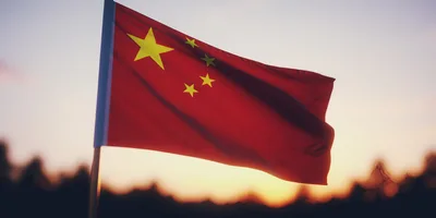 Waving Flag Of China Against A Sunset Sky