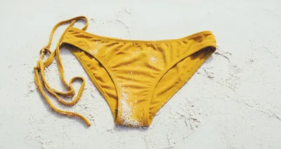Yellow Bikini Bottoms On White Sand Beach