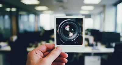 Hand Holding A Polaroid Photo Of A Camera Lens