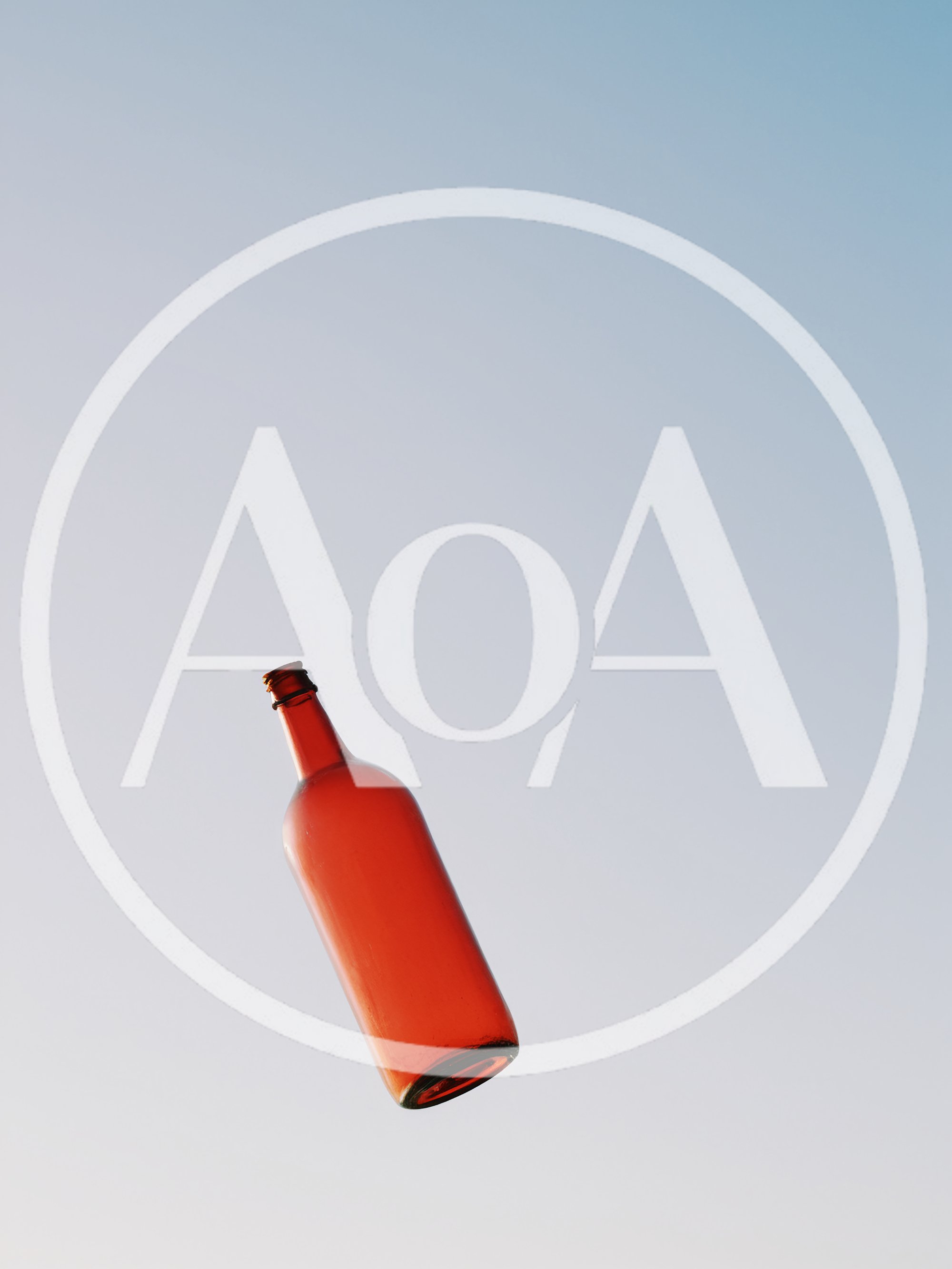 Red Glass Bottle Floating Against Clear Blue Sky