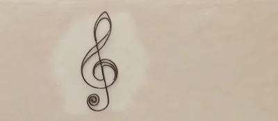Metal Treble Clef Symbol on Textured Beige Background