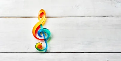 Colorful Glass Treble Clef on White Wooden Background
