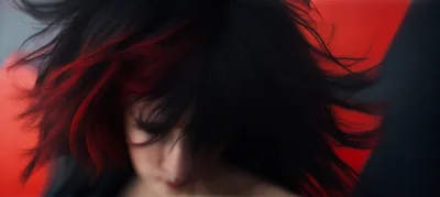 Woman With Black And Red Hair Flipping Her Head
