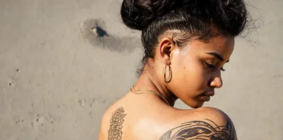 Young Woman With Tattoos Looking Down Outdoors