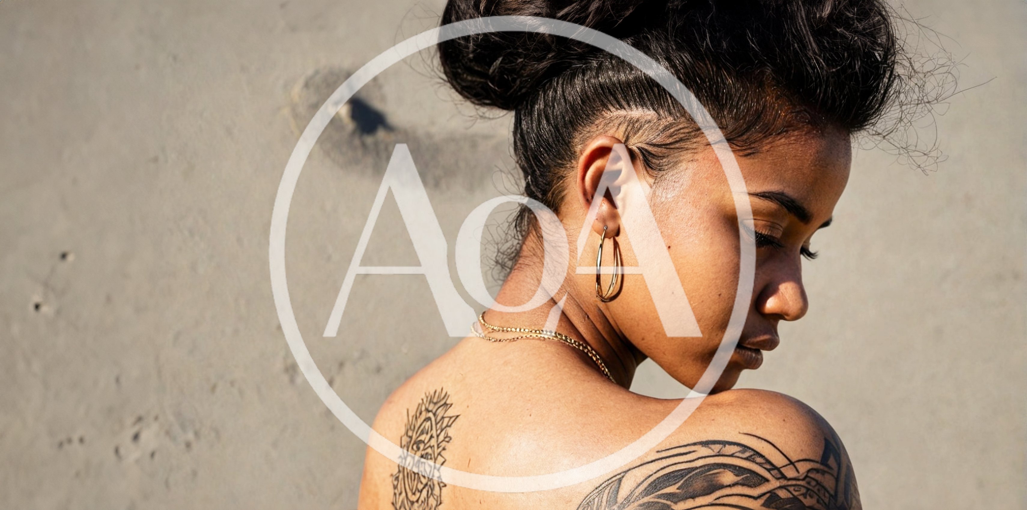 Young Woman With Tattoos Looking Down Outdoors