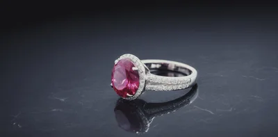 Elegant Ruby Ring With Diamond Halo On Dark Surface