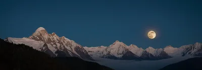Full Moon Rising Over Snow Covered Himalayan Mountains